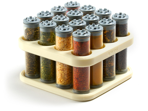 A spice rack with a grid-like design holds multiple clear tubes filled with various colorful spices, neatly organized on a white background.